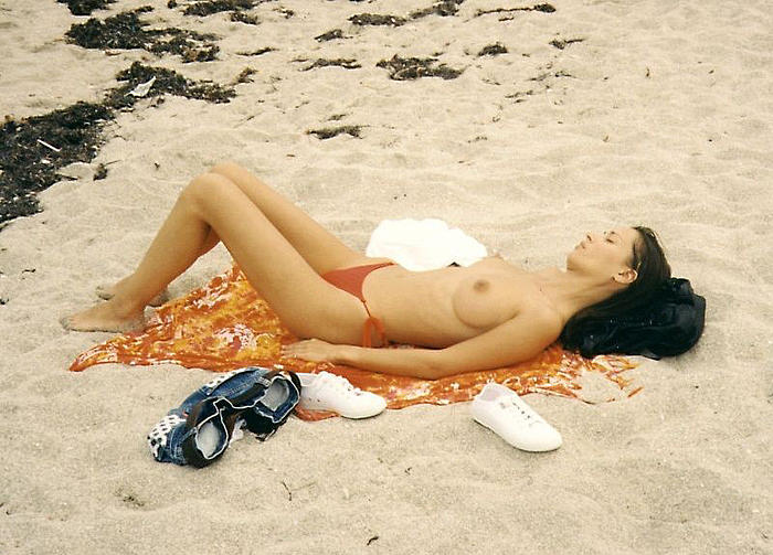 Christy Turlington sunbathint topless on the beach