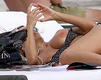 Rita Rusic sunbathing almost topless shows her nude boobs