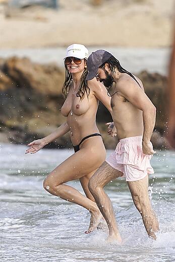 Heidi Klum in bikini and topless on the beach in St. Barths - December 12, 2025
