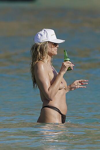 Heidi Klum in bikini and topless on the beach in St. Barths - December 12, 2025