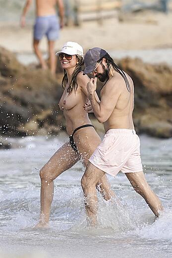 Heidi Klum in bikini and topless on the beach in St. Barths - December 12, 2025