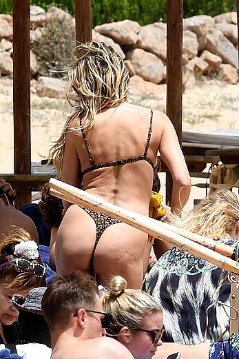Heidi Klum in bikini and topless on a beach in Sardinia