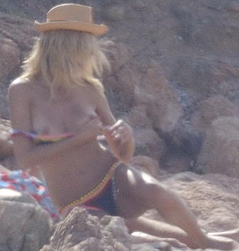 Supermodel Heidi Klum sunbathing topless at a beach in Italy