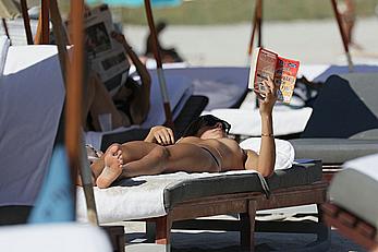 Lucy Aragon sunbathing topless on a beach