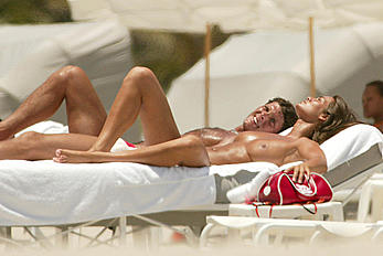 Italian actress Manuela Arcuri sunbathing topless on a beach